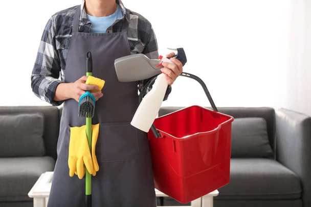 Jovem homem asiático com suprimentos de limpeza em casa
 - Foto, Imagem