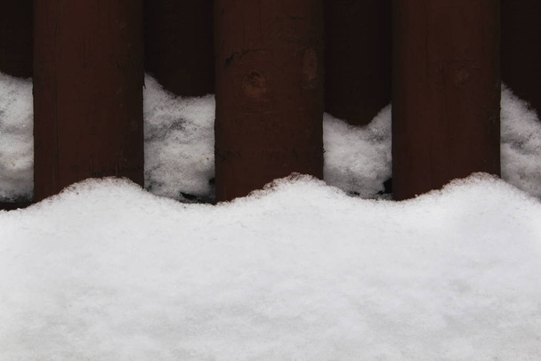 Коричневий дерев'яний паркан деталі з хвилястими снігопадами
 - Фото, зображення