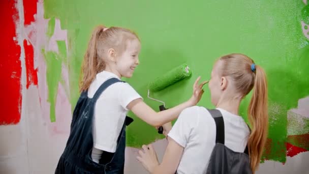 Tochter beschmiert Mutter beim Bau mit grüner Farbe - Filmmaterial, Video