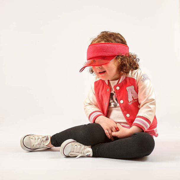 Little girl with red cap standing and smiling - Foto, Imagen