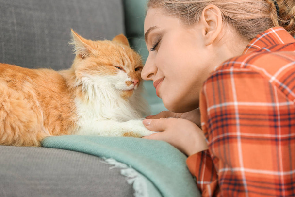 Beautiful young woman with cute cat at home - Photo, Image