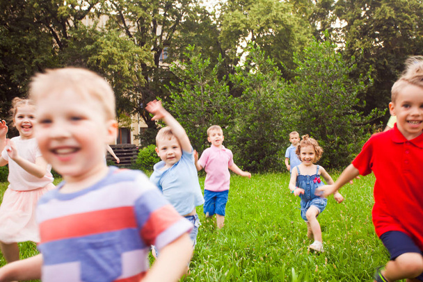 Large group of kids running in the park - Foto, Imagen