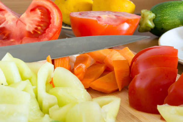Kitchen full of various vegetables. Pepper, tomatoes sliced and ready to be boiled - 写真・画像