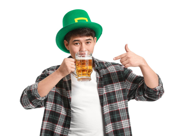 Jonge Aziatische man met bier op witte achtergrond. St. Patrick 's Day viering - Foto, afbeelding