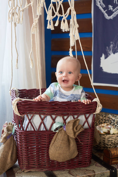 Happy little baby boy is plaing in the basket in the room. Six month - Photo, image