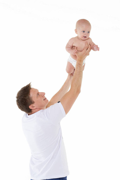 Young father and little baby boy are playing on a white background. Happy family. Six month - Foto, Imagen