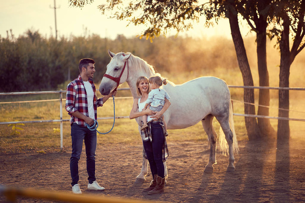 Happy family on the horse ranch .Young happy family having fun a - Foto, afbeelding