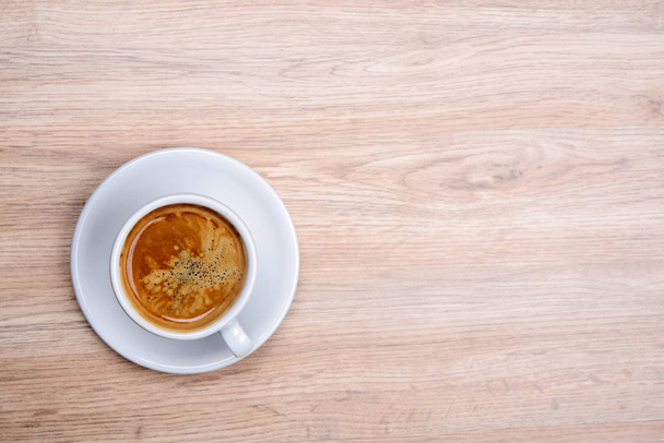 cup of coffee on wooden table from above - Fotoğraf, Görsel