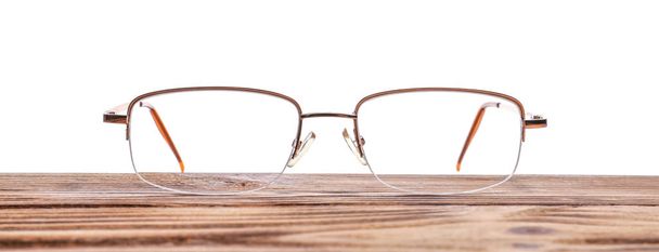 Стильные очки на деревянном столе на белом фоне
 - Фото, изображение