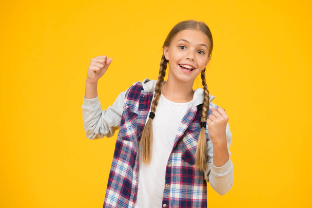 Change for the better. school girl casual style. autumn kid fashion. child cute blond hair. childhood happiness. happy childrens day. small girl checkered jacket. hipster girl yellow wall - Photo, Image