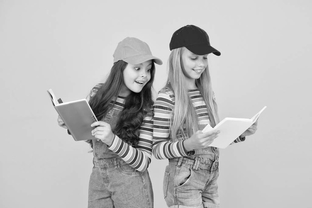 Kids girls with books study together. Study group can help solidify and clarify material. Back to school. Learning foreign languages. Effective study groups help students learn material deeper - Φωτογραφία, εικόνα