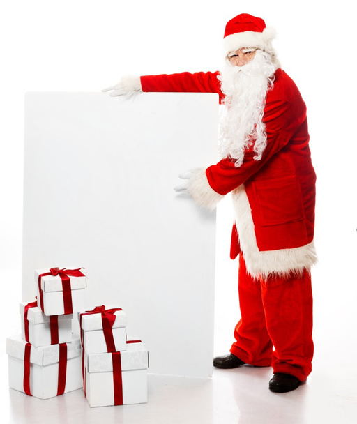 Santa Claus with many gift boxes and blank notice board - Zdjęcie, obraz