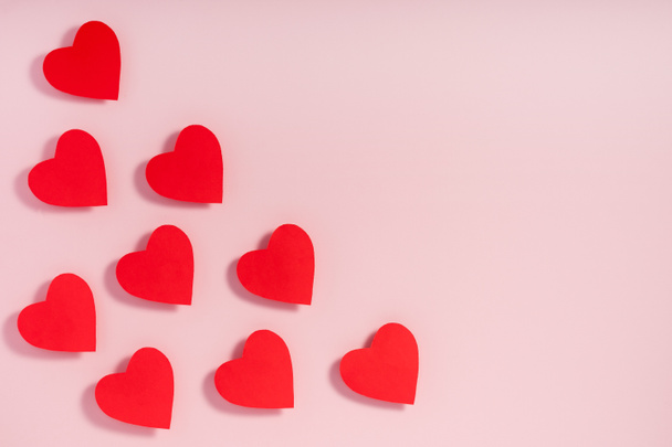 Sevgililer Günü. Pembe yüzeyinde gölgesi olan kırmızı kağıt kalpler.. - Fotoğraf, Görsel