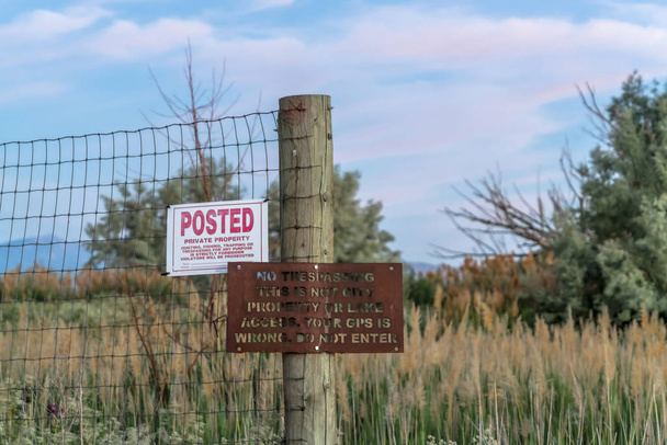 Rusty wire fence with old No Trespassing and Posted signs at a private property - Photo, Image