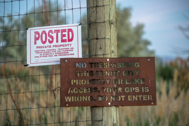 Posted and No Trespassing signs against wire fence of a private property - Photo, Image