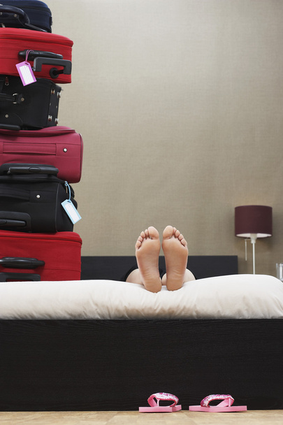 Person in bed next to suitcases - Foto, immagini