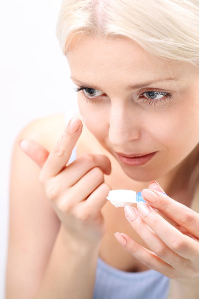 contact lenses. insertion of contact lenses. the woman puts on contact lenses. - Foto, Bild