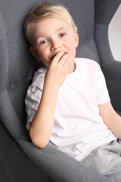 портрет мальчика, сидящего на стуле
. - Фото, изображение
