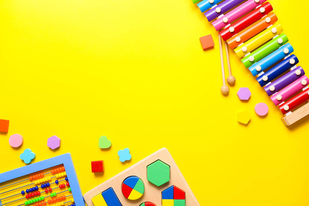 Colorful kids toys on yellow background. Top view, flat lay. - Photo, Image