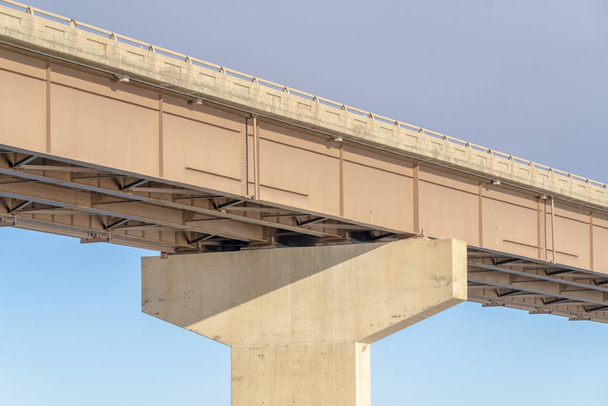 Vista sob uma ponte de longarina com pilar maciço que suporta o convés
 - Foto, Imagem