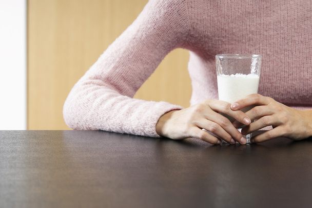 Woman holding glass of milk - 写真・画像