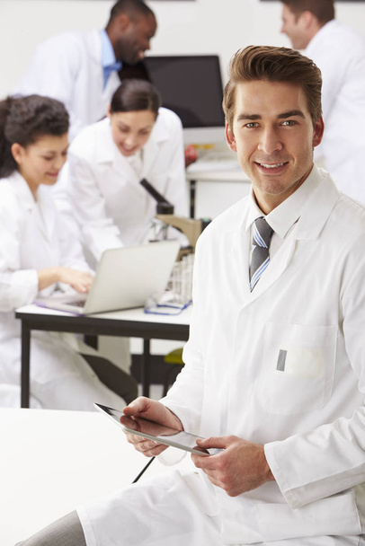 Portrait Of Technician In Laboratory With Colleagues - Foto, Bild