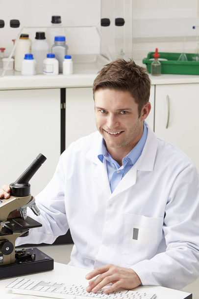 Portrait Of Scientist With Microscope In Laboratory - Фото, изображение