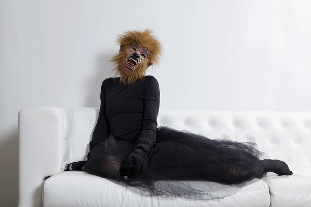 werewolf woman wearing a tutu and sitting on a white sofa - Фото, зображення