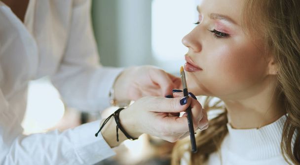 beautiful young model woman getting fashion make-up - Фото, изображение