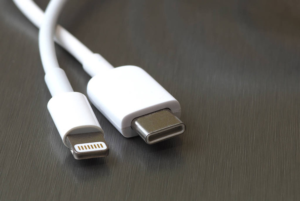 USB type C and lightning white cable connector on a gray metal background - Photo, Image