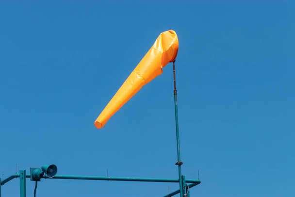 Baharda güneş ışığında esen turuncu rüzgar çorabı. - Fotoğraf, Görsel