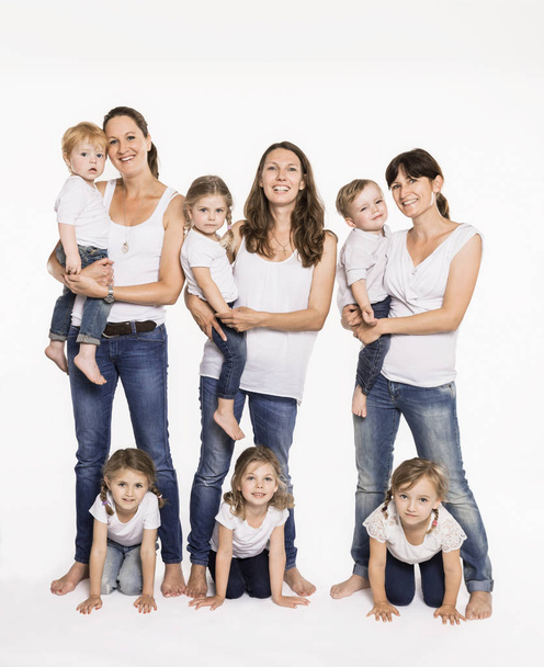 Studio portrait of three mid adult mothers and six children - Фото, изображение
