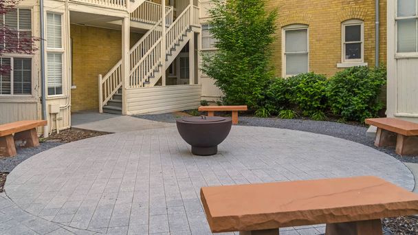 Panorama frame Fire pit on circular pavement with stone benches against building exterior - Fotografie, Obrázek