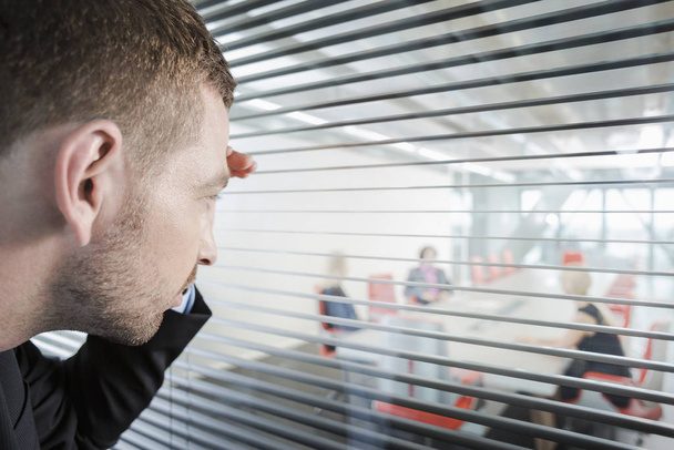 Man peering through window blinds - Foto, imagen