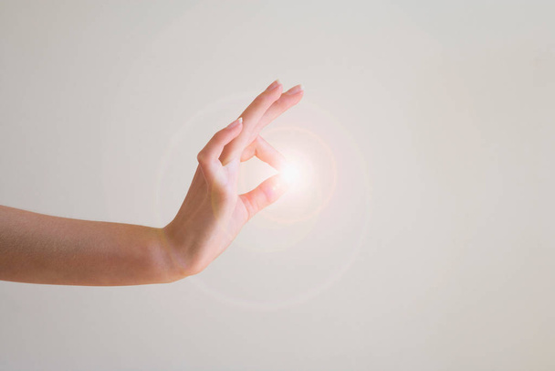 Finger and thumb connecting with light - Φωτογραφία, εικόνα