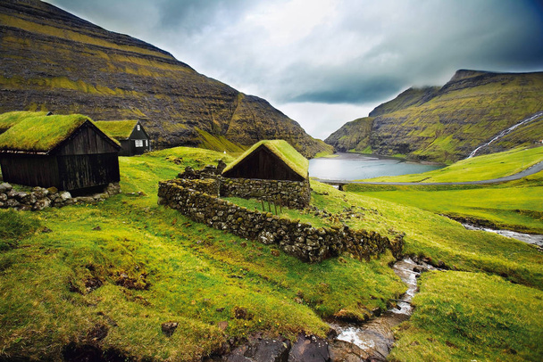Stone houses on grassy mountainside - Foto, Imagen