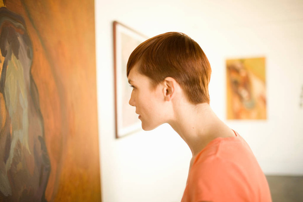 Woman in art museum looking at painting - Photo, Image