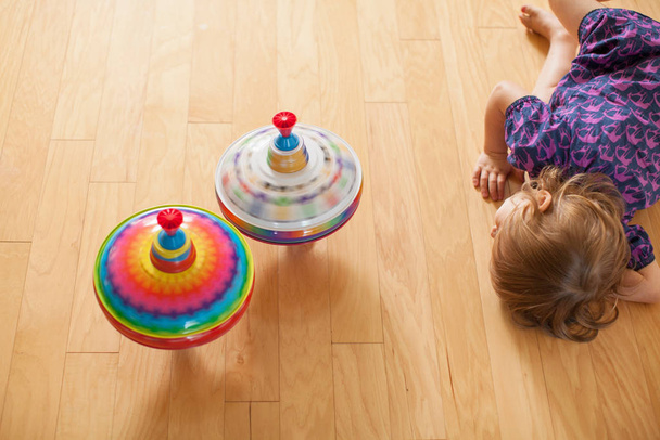 Girl playing with spinning tops - 写真・画像