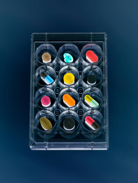 A variety of drugs sitting in a multi well sample tray Illustrating drug clinical trial - Фото, изображение
