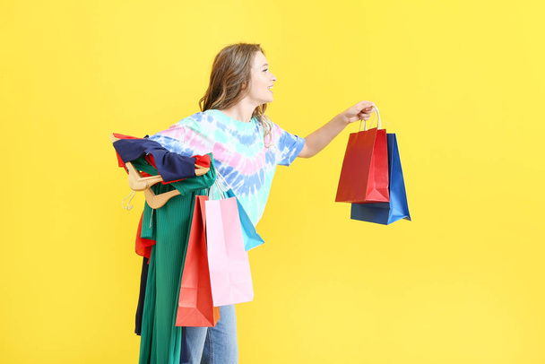 Female stylist with shopping bags on color background - Photo, Image