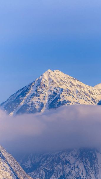 Vertikální rám Bičující sníh pokrytý Mount Timpanogos s modrým nebem pozadí v zimě - Fotografie, Obrázek