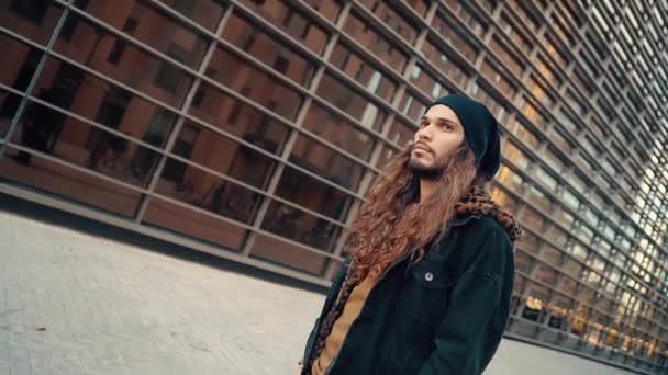 Portrait de hipster aux cheveux longs marchant dans la rue dans la ville moderne
 - Séquence, vidéo