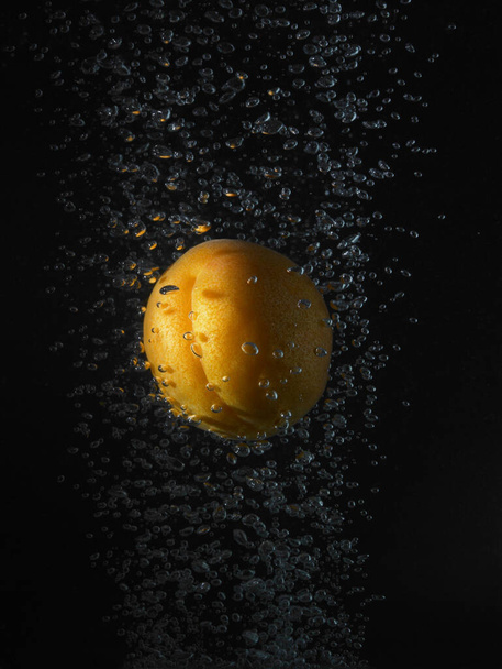 Apricot in bubbles, black background - Fotoğraf, Görsel