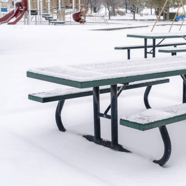 Photo Square Mesas y bancos de picnic nevados en un parque cubierto de nieve en invierno
 - Foto, Imagen