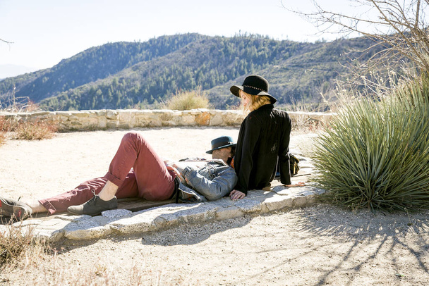 Young couple relaxing on viewing platform overlooking mountains, Chilao Campgrounds, Los Angeles, California, USA - Valokuva, kuva
