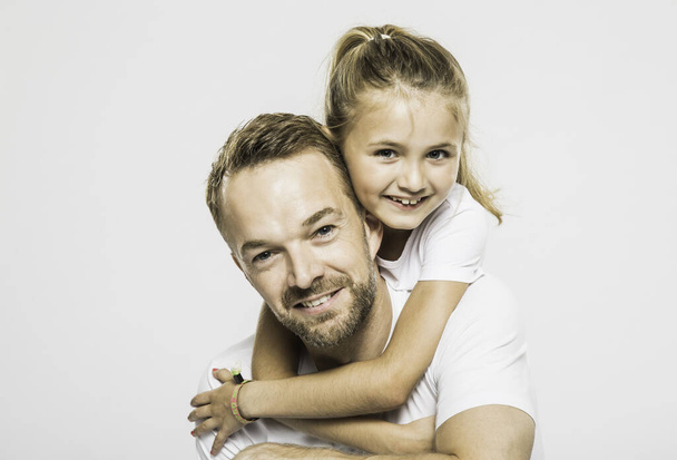 Studio portrait of girl getting piggyback from father - Photo, image