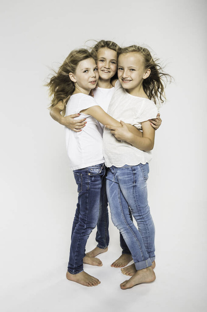 Studio portrait of three girls hugging - Fotoğraf, Görsel
