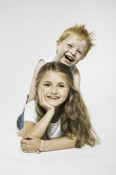 Studio portrait of boy getting piggy from sister - Photo, Image