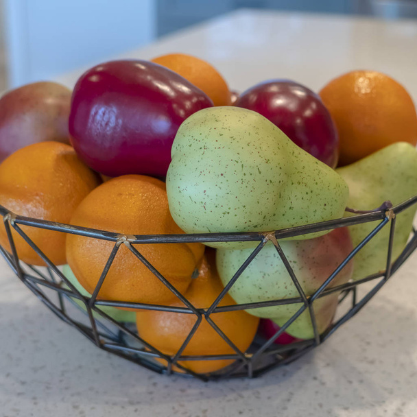 Photo Square Καλαθάκι γεωμετρικό με φρέσκα φρούτα ενάντια βρύση νησίδας κουζίνας και νεροχύτη - Φωτογραφία, εικόνα