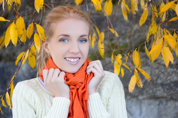 portrait of beautiful woman in white sweater posing against ston - Photo, Image